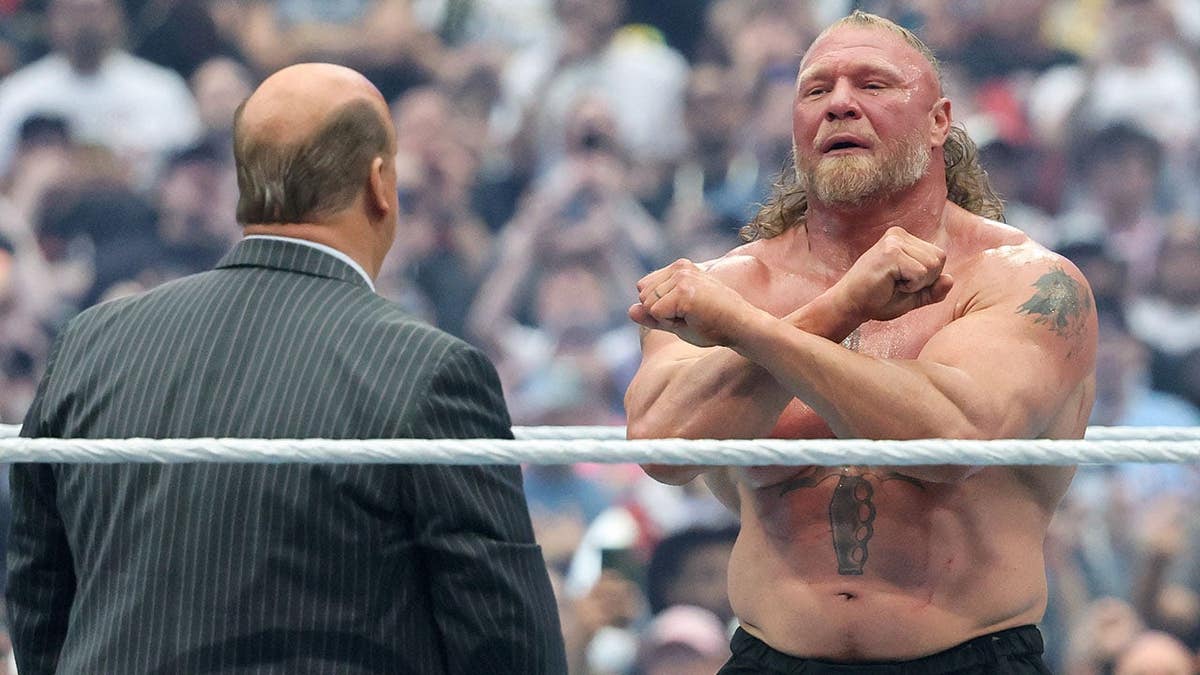 Paul Heyman consoling Brock Lesnar in a wrestling ring at Allegiant Stadium
