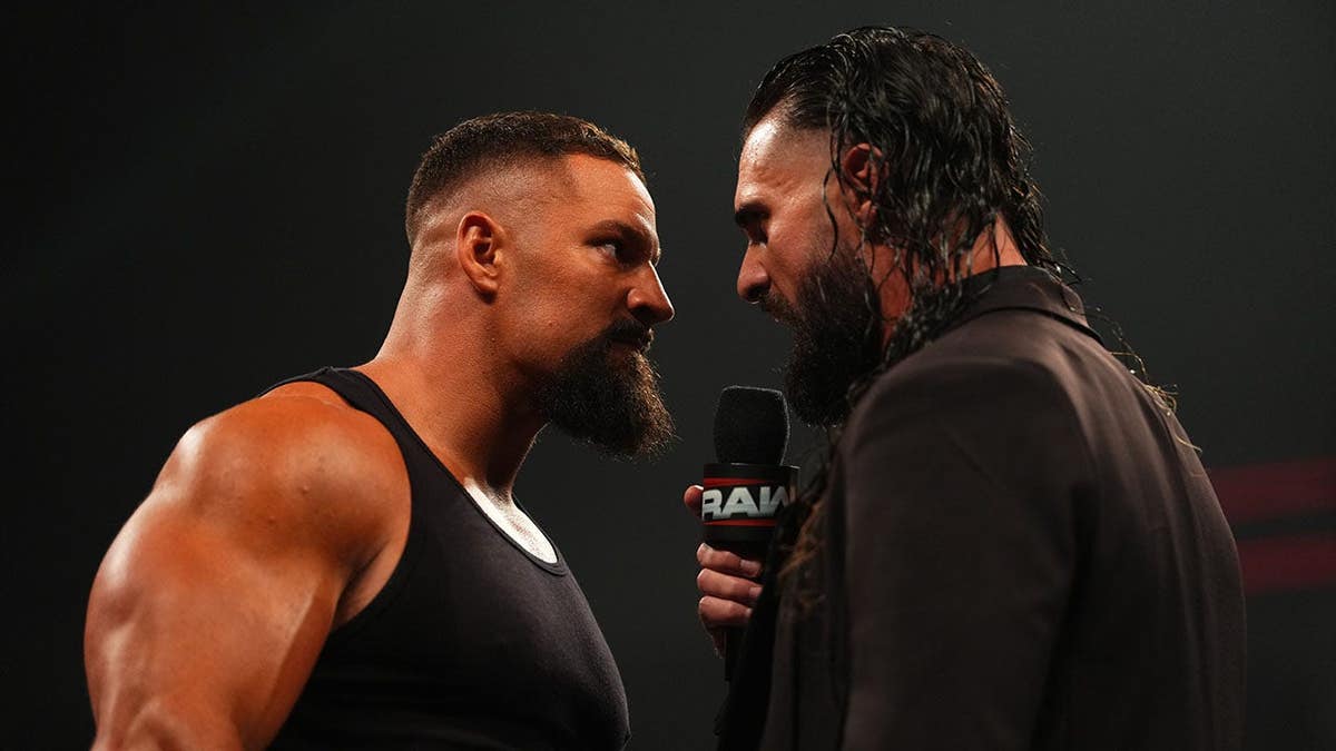 Bron Breakker and Seth Rollins facing off in a wrestling ring at Sames Auto Arena