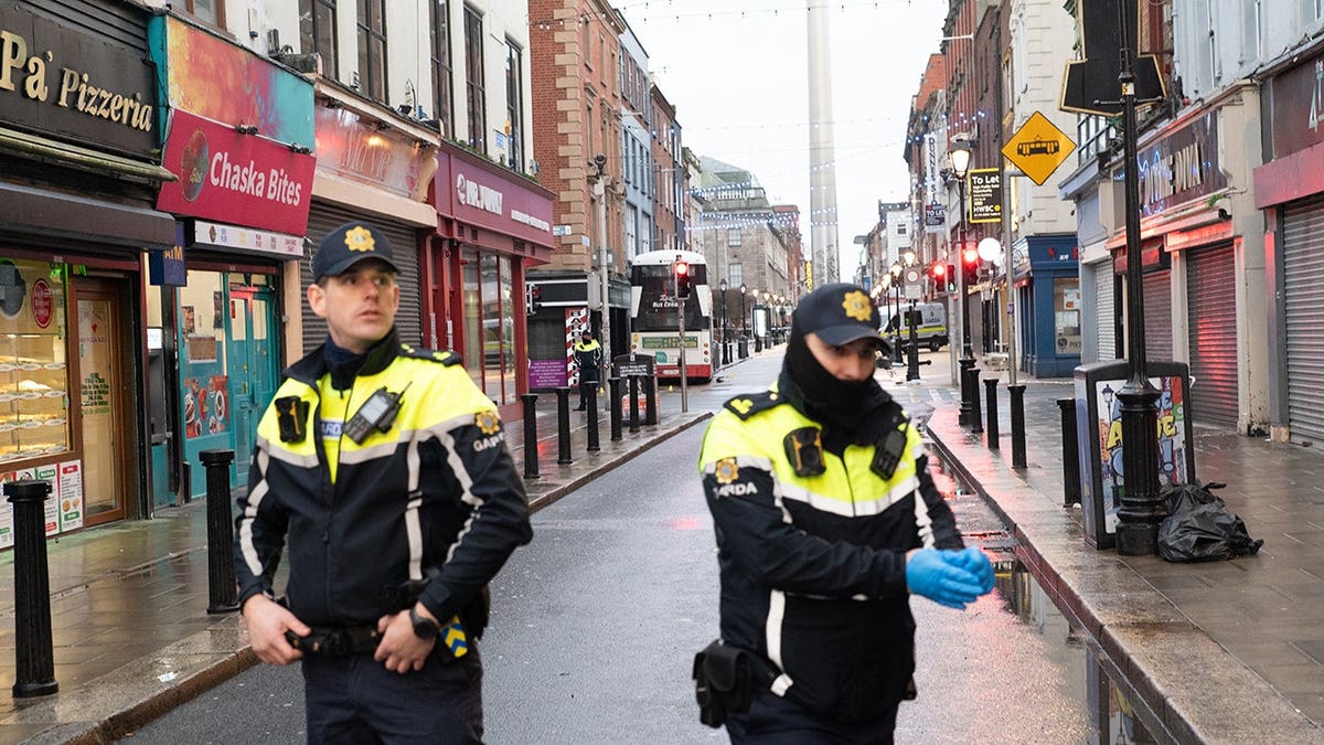 Members of An Garda Síochána standing near a crashed double-decker bus in Dublin