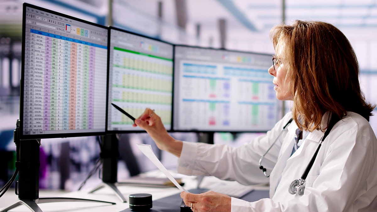 A doctor analyses data on a computer screen.
