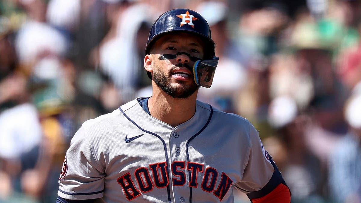 Houston Astros' Carlos Correa reacting after striking out during a baseball game.