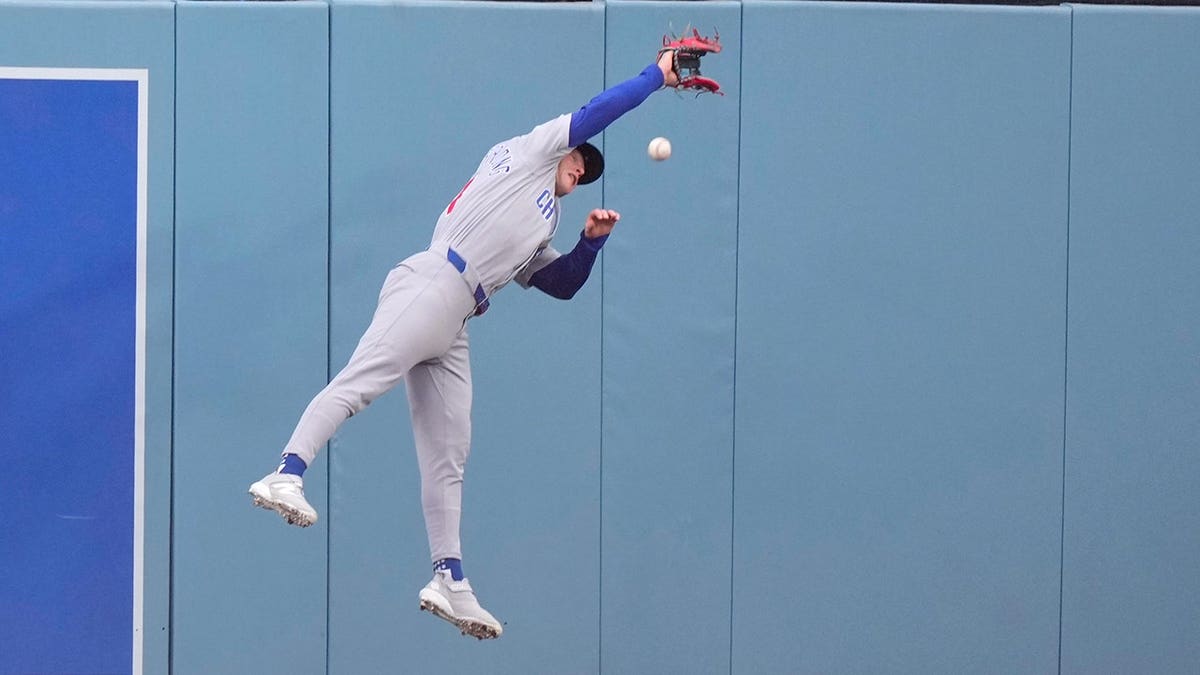 Chicago Cubs center fielder Pete Crow-Armstrong reaching for a ball during a baseball game