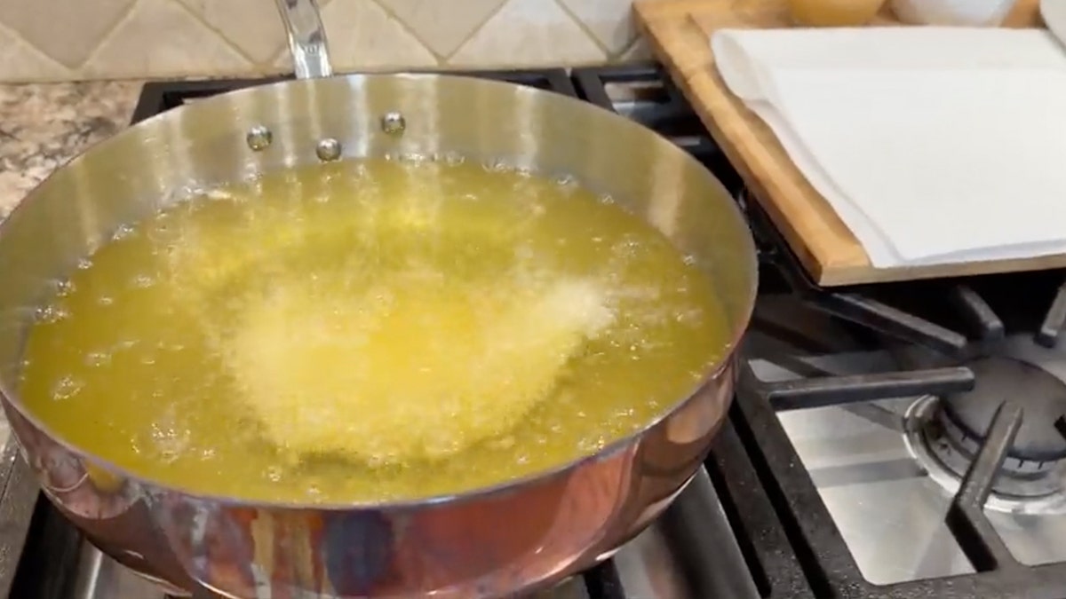 Fried chicken frying in vat of oil