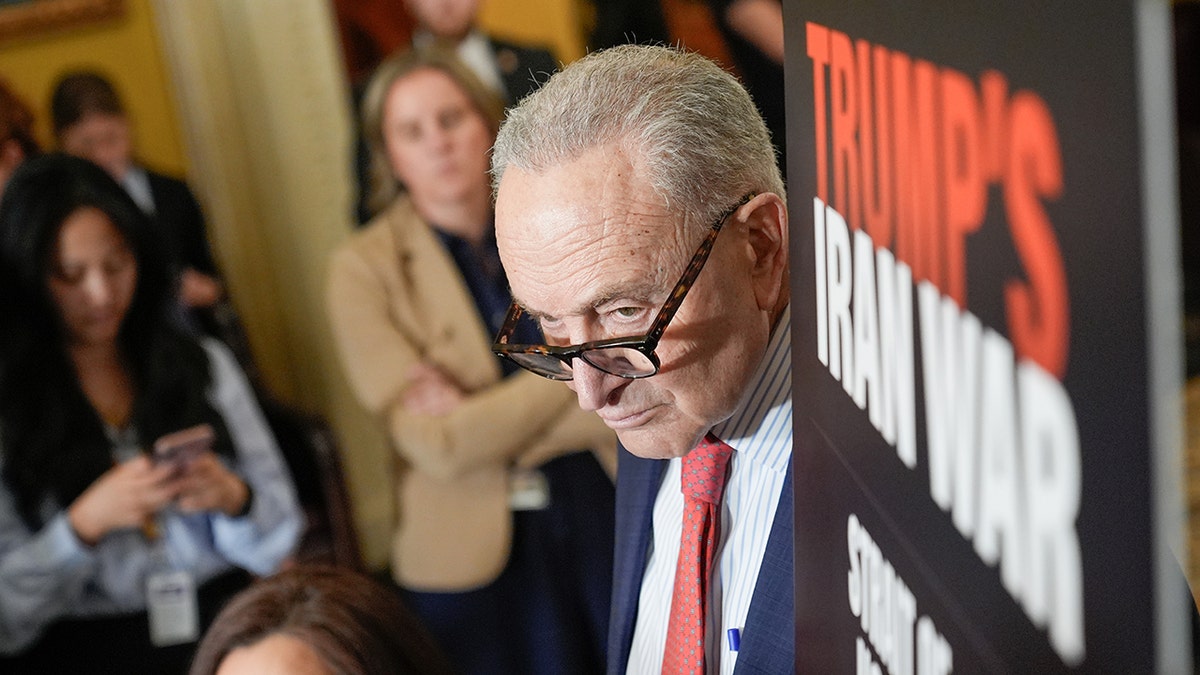 Senate Minority Leader Chuck Schumer standing at a podium during a news conference