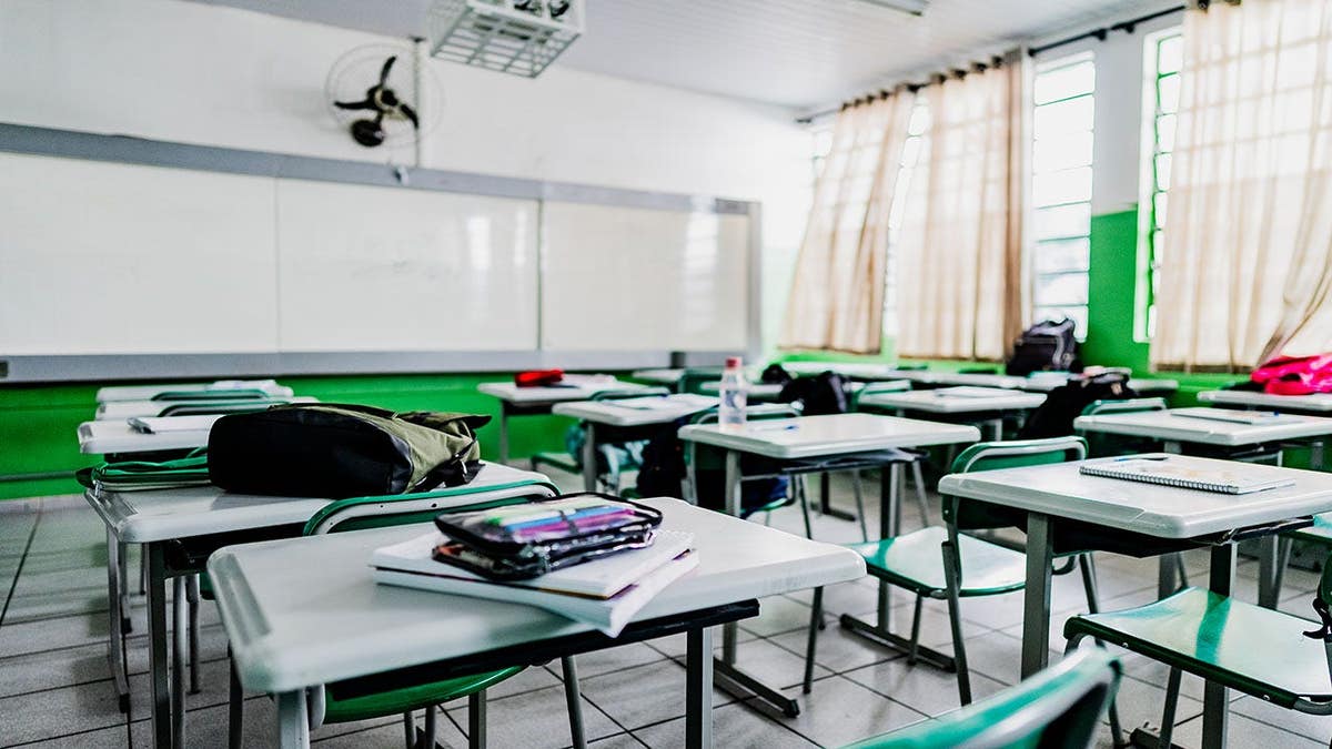 Classroom with organized desks and green chairs lit by natural light