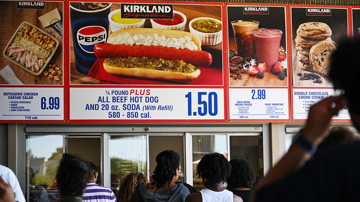 Costco food court offerings seen above crowd, including $1.50 hot dog combo meal.