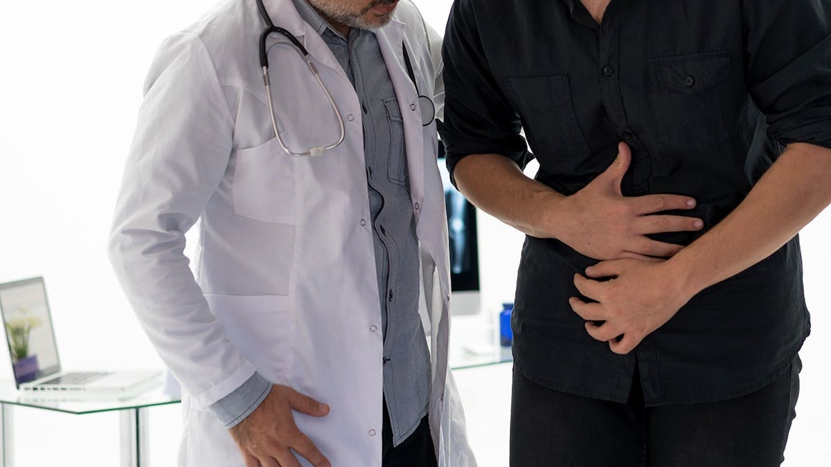 Doctor examining abdomen of patient in medical setting