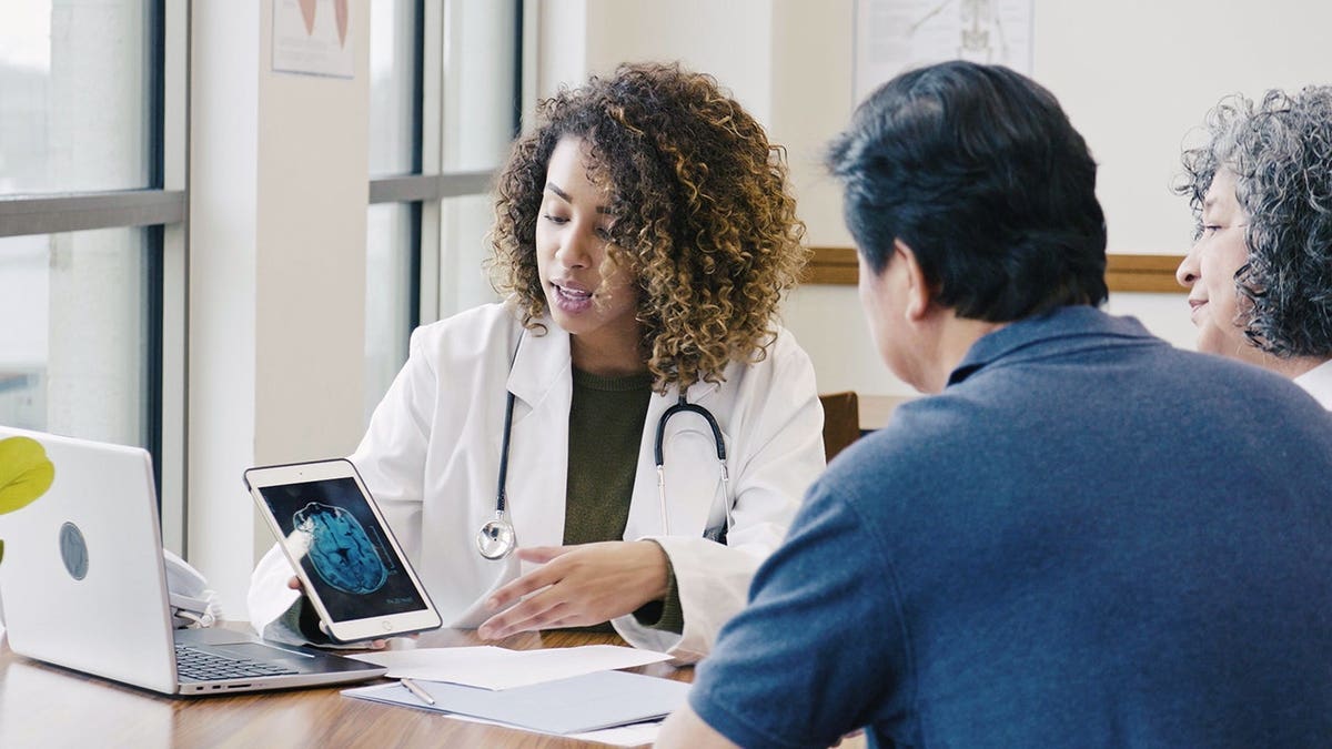 Doctor explaining medical results on a tablet to patients indoors