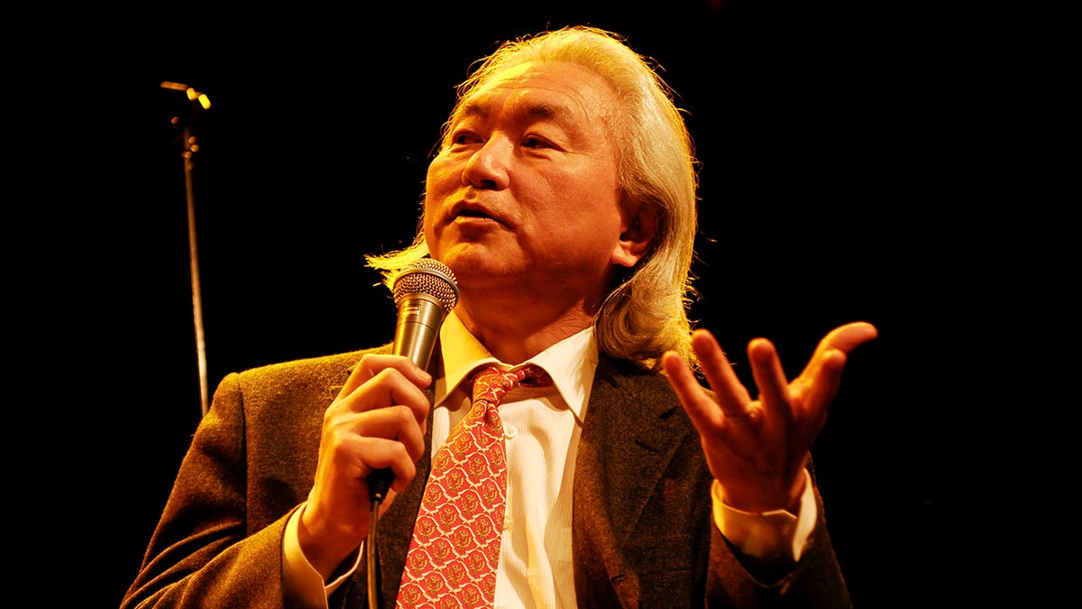 Dr Michio Kaku speaking into a microphone on a panel