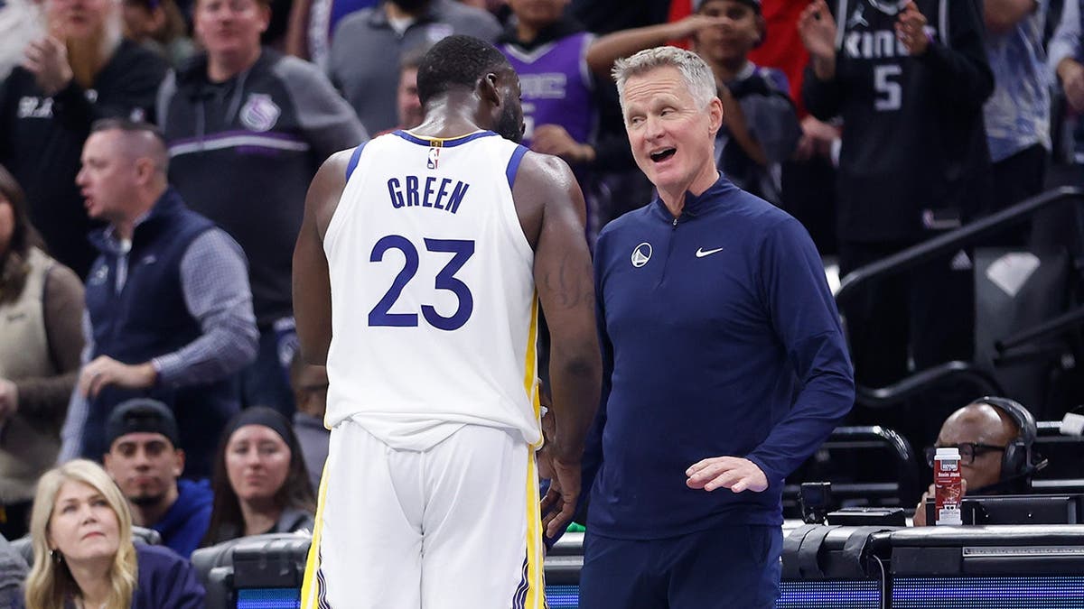 Draymond Green talking to head coach Steve Kerr during an NBA game at Golden 1 Center in Sacramento