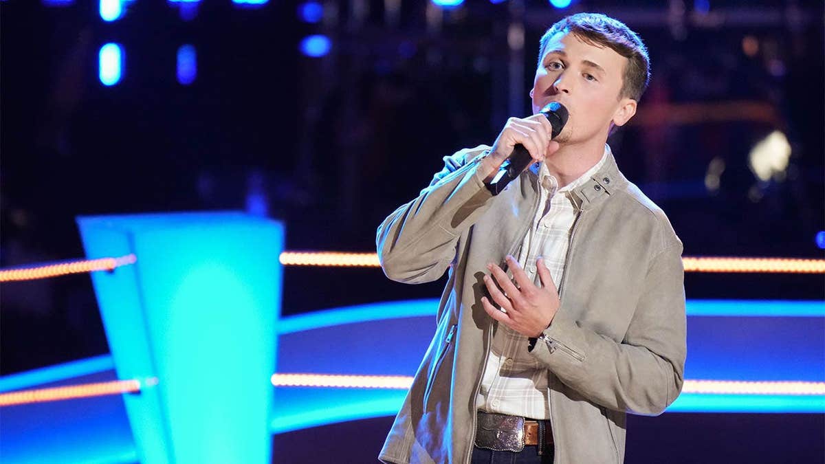 Dylan Carter singing on stage during The Voice battles episode