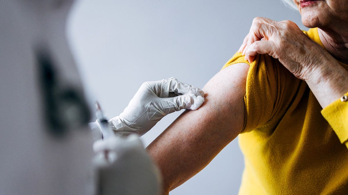 Healthcare nonrecreational  administering vaccination to aged  pistillate   seated