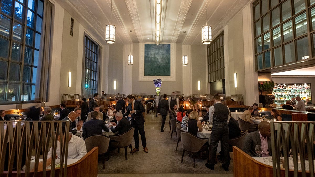 La sala da pranzo del ristorante Eleven Madison Park di New York City con tavoli apparecchiati per gli ospiti.