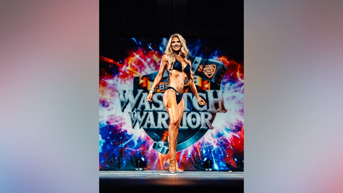 Elizabeth Smart standing and smiling in a bodybuilding competition setting