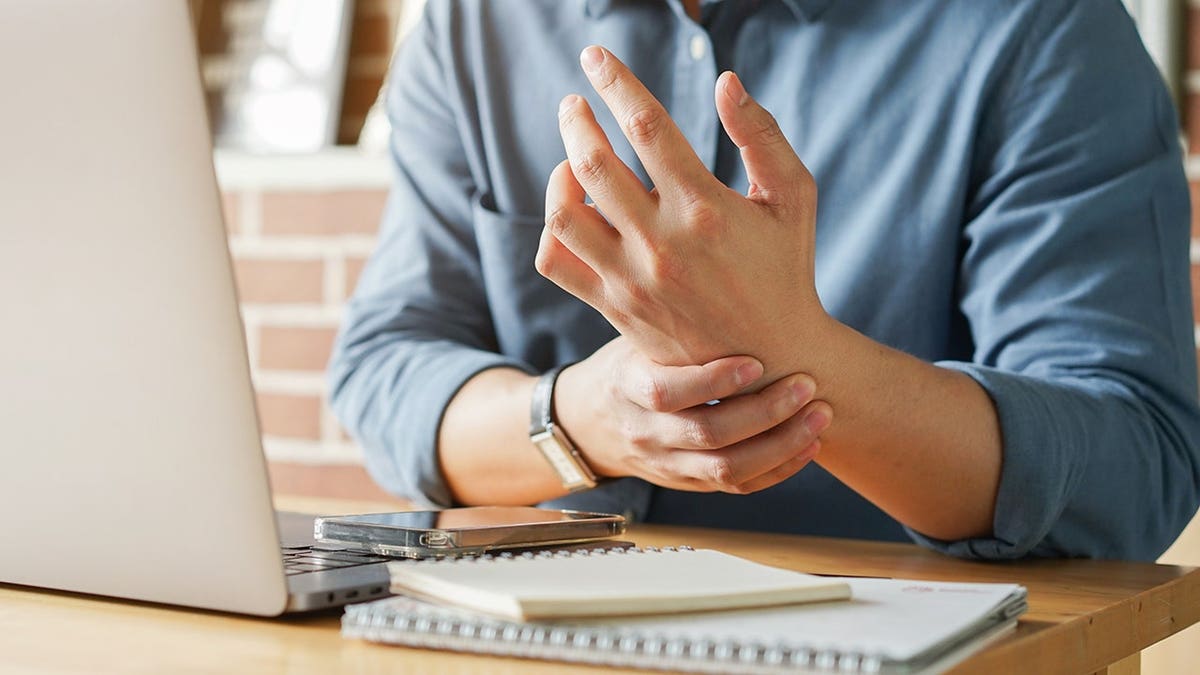Employee massaging his hand and arm for pain relief