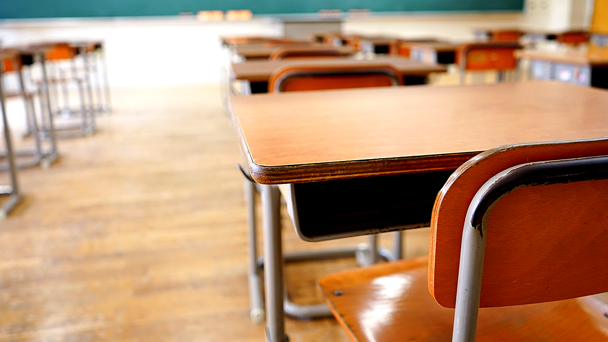 Stock image of a wooden desk in a classroom