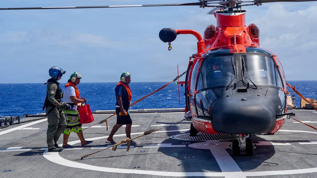 Family walking towards the chopper aft a U.S. Coast Guard rescue.