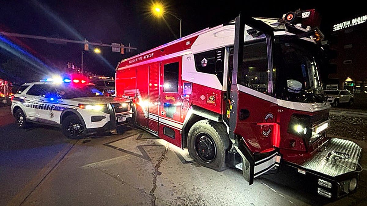 sheriff's car flashing lights next to fire truck at night