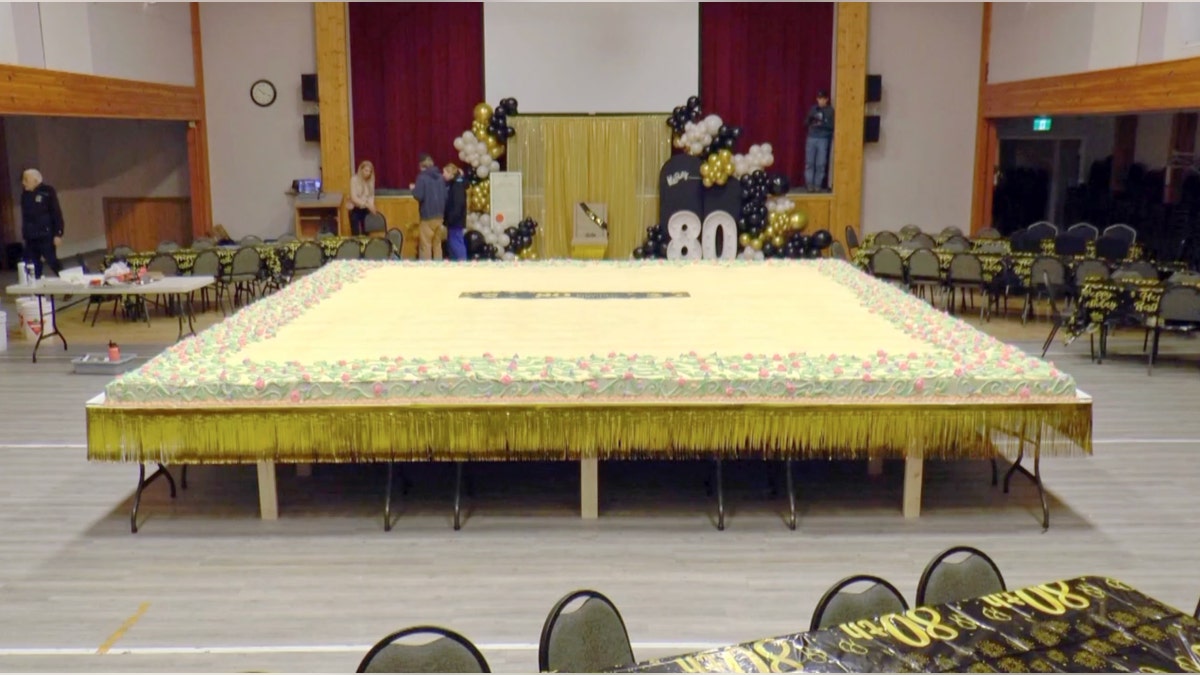 Esta é a vista de um bolo de cenoura gigante em exibição antes de uma festa de aniversário de 80 anos.