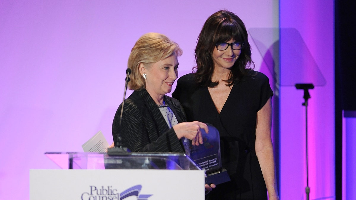 Hillary Clinton receives an award while Mary Steenburgen stands nearby