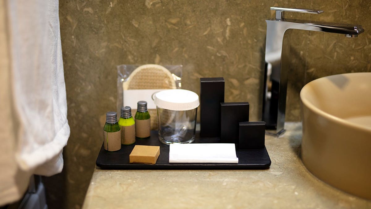 Close up of cosmetic bottles arranged in a hotel bathroom