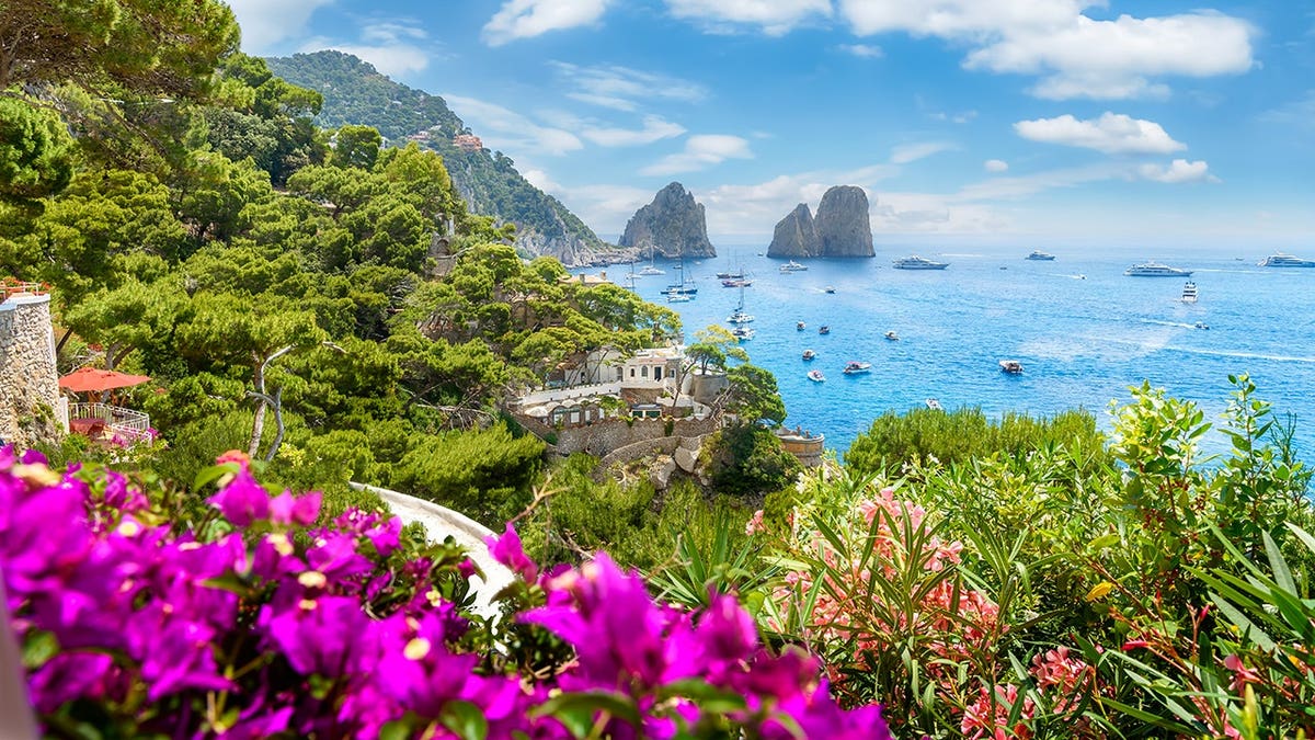 Scenic coastal view of Capri, Italy with Faraglioni rock formations.