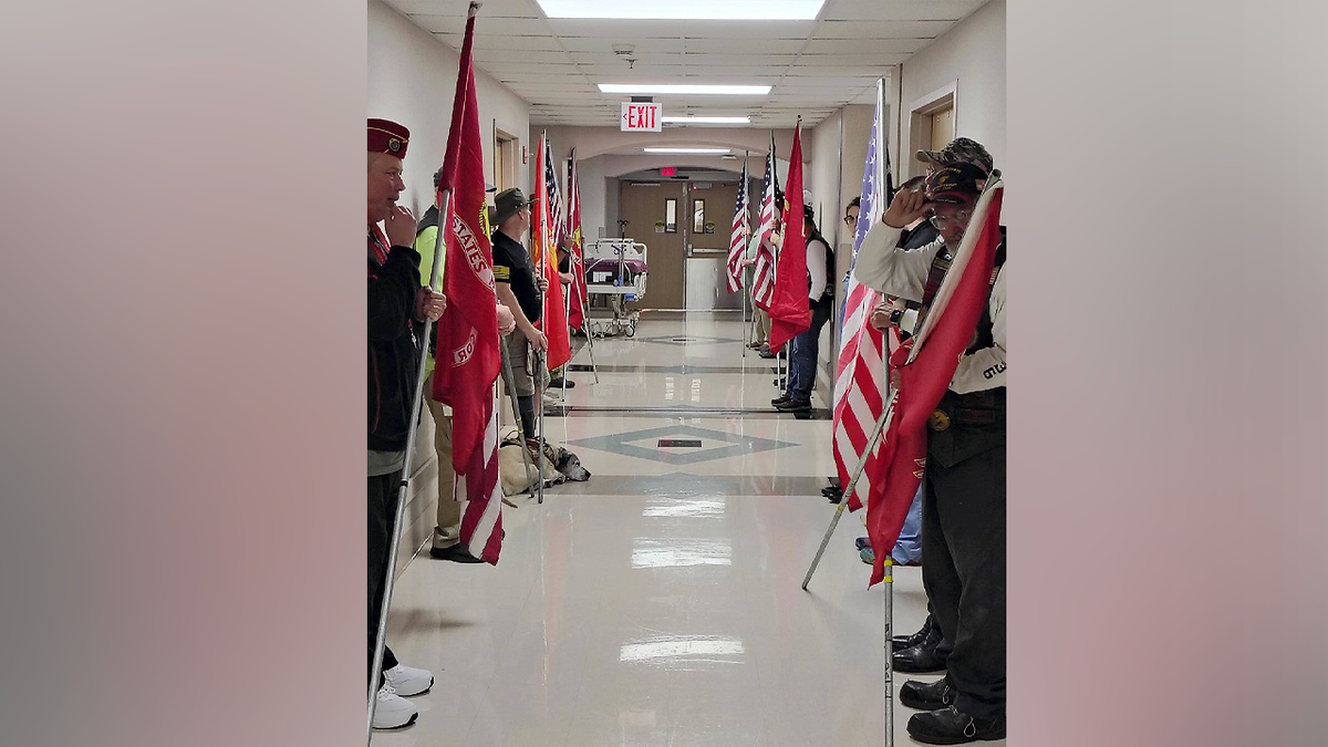 Veterans hold flags during honor walk for Marine veteran Ivy Unruh organ donation