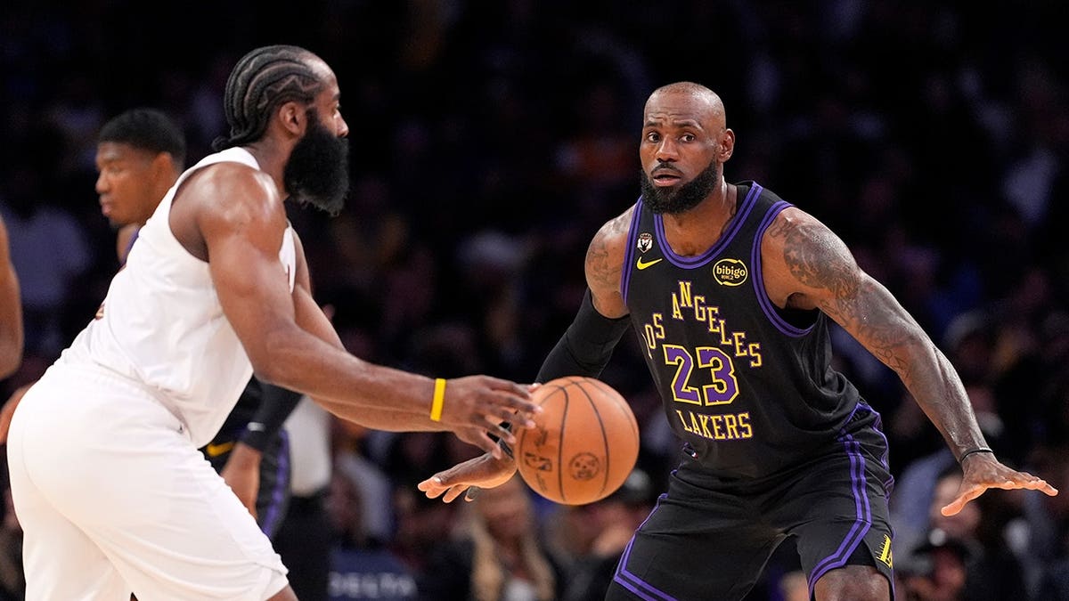 Cleveland Cavaliers guard James Harden dribbling as Los Angeles Lakers forward LeBron James defends