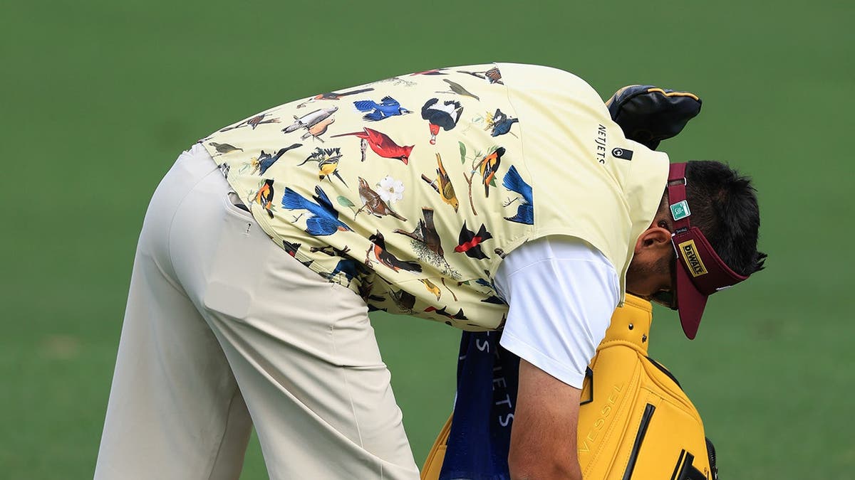 Jason Day practicing golf at Augusta National Golf Club practice area.