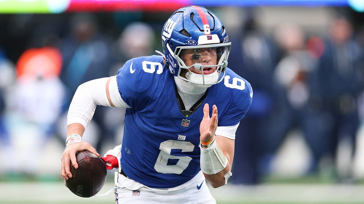 New York Giants quarterback Jaxson Dart scrambling during a football game at MetLife Stadium