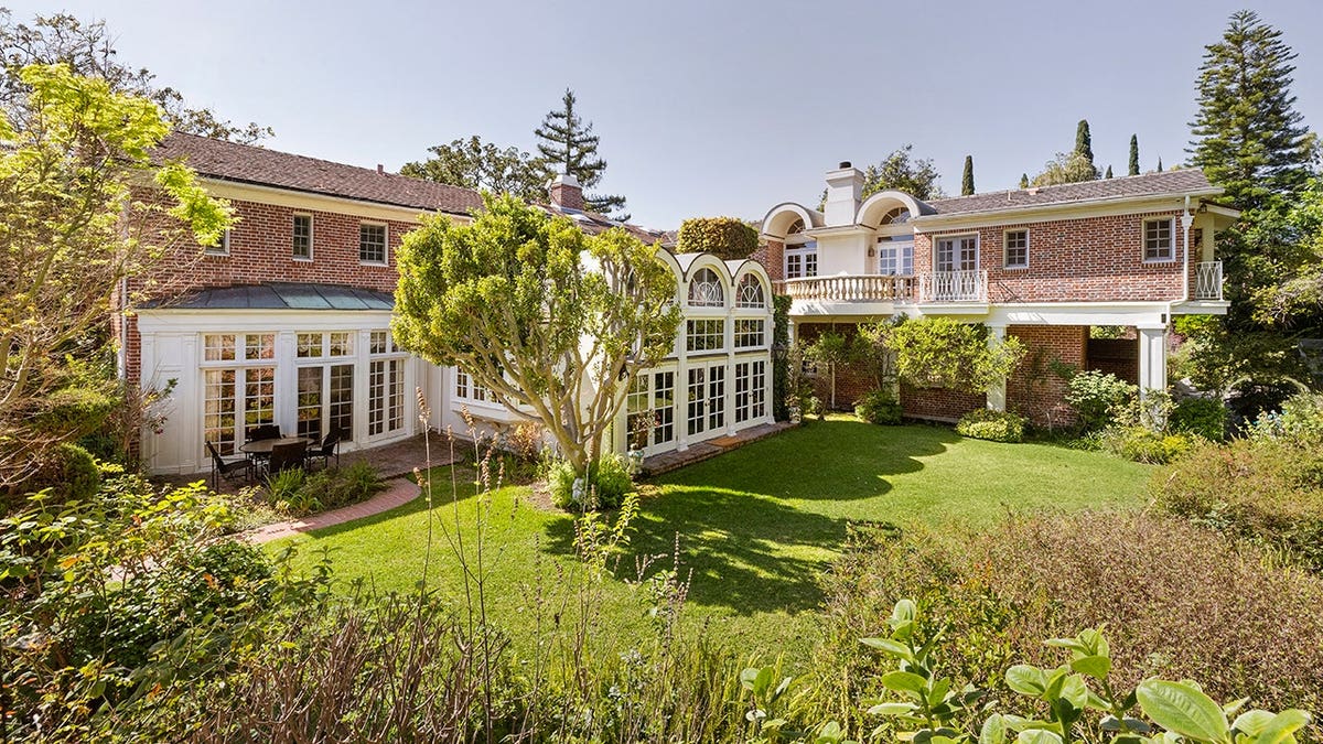 A backyard with a manicured lawn and trees