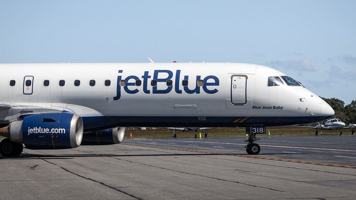 JetBlue airplane connected  runway nether  wide   bluish  sky