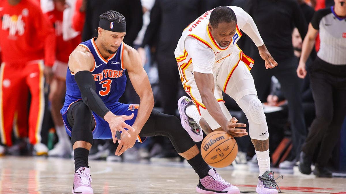 New York Knicks guard Josh Hart having the ball stolen by Atlanta Hawks forward Jonathan Kuminga during a basketball game.