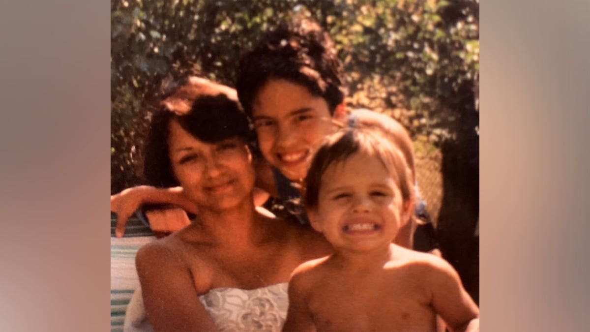 Juanita Zdroik posing with two children in a photo