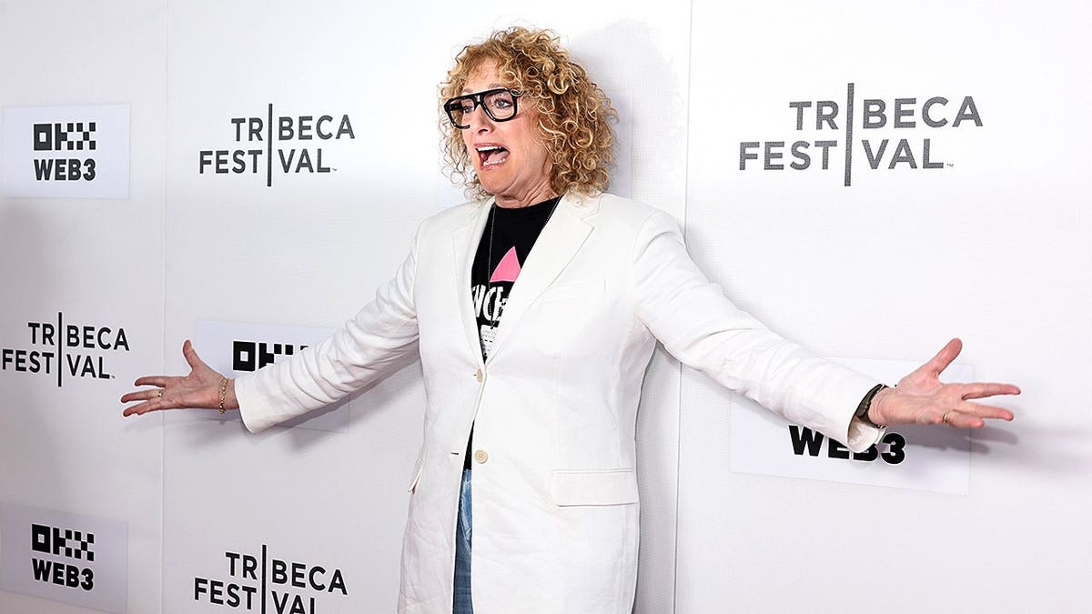 Judy Gold standing on stage at the SVA Theater in New York City