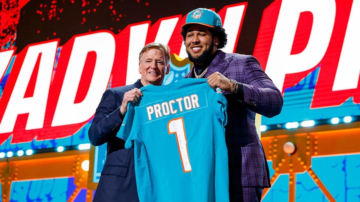 Kadyn Proctor posing with NFL Commissioner Roger Goodell at NFL Draft event