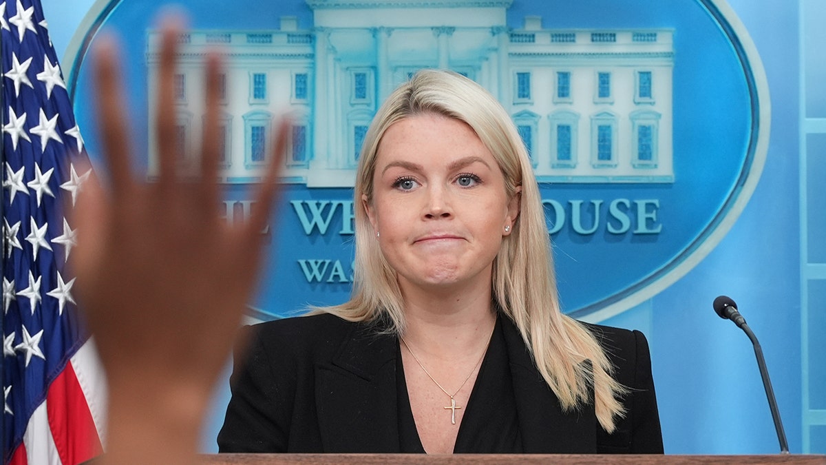 Karoline Leavitt speaking at a lectern in the James Brady Press Briefing Room.