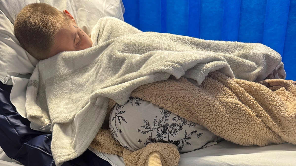 Kayley Boda lying in bed with blankets after surgery.