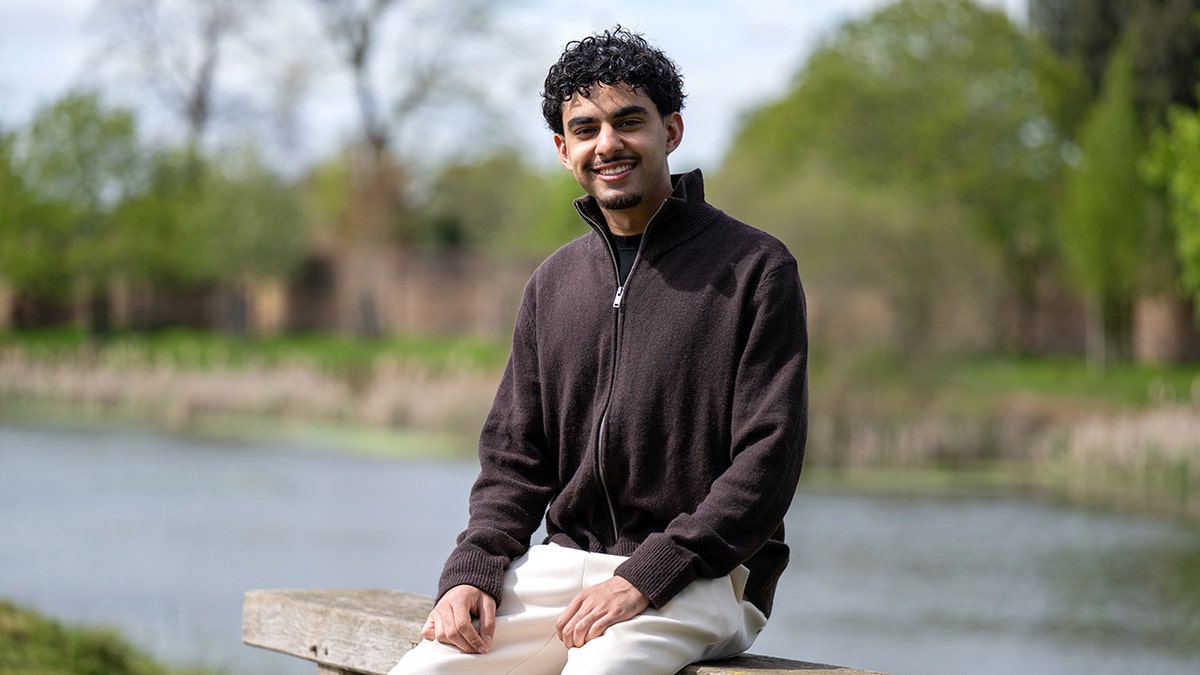 Khaled Sharif sitting on bench by the river.