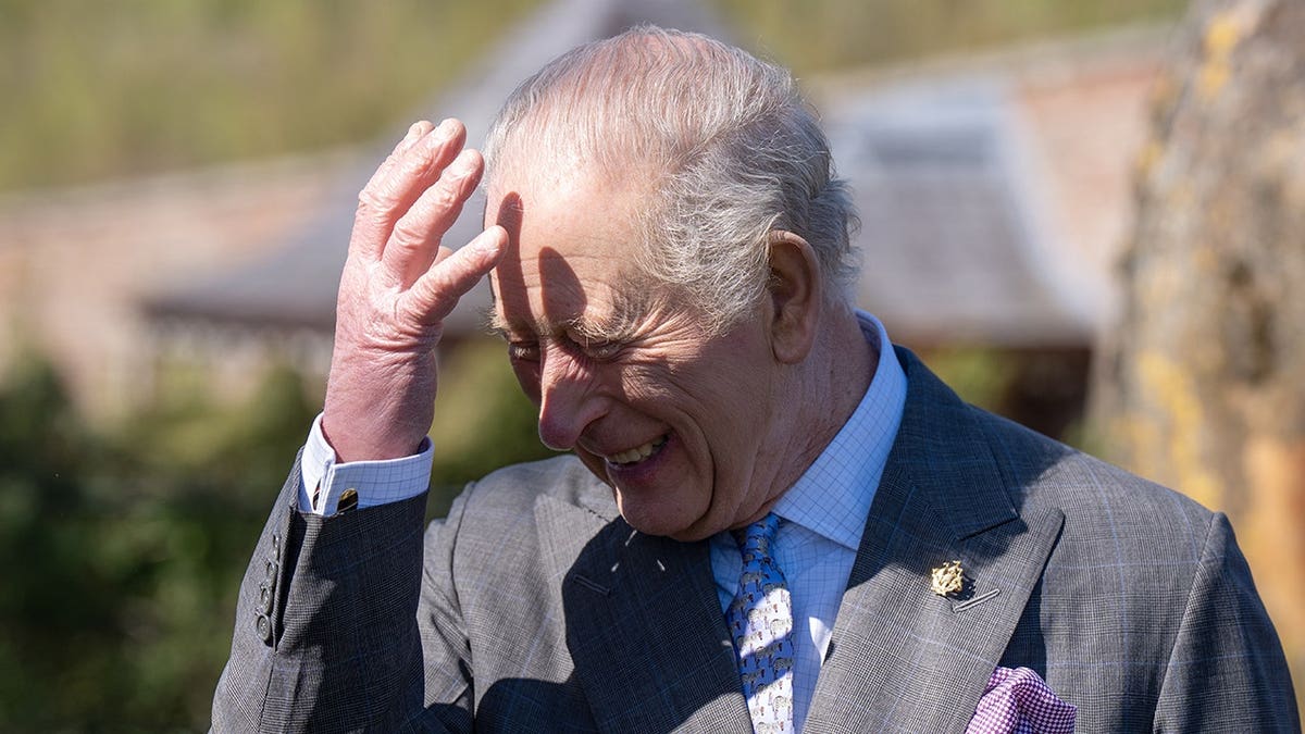 King Charles III reacting while receiving a Green Blue Peter badge at Dumfries House in Scotland