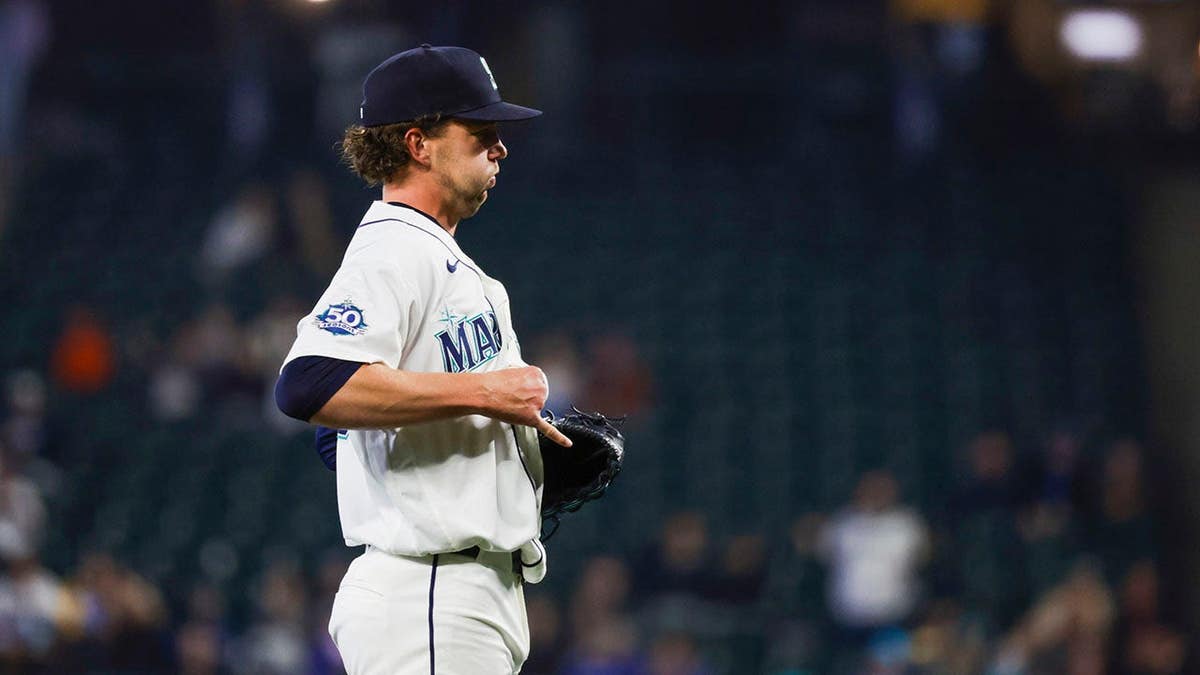 Seattle Mariners starting pitcher Logan Gilbert reacts with a ball trapped under his jersey at T-Mobile Park