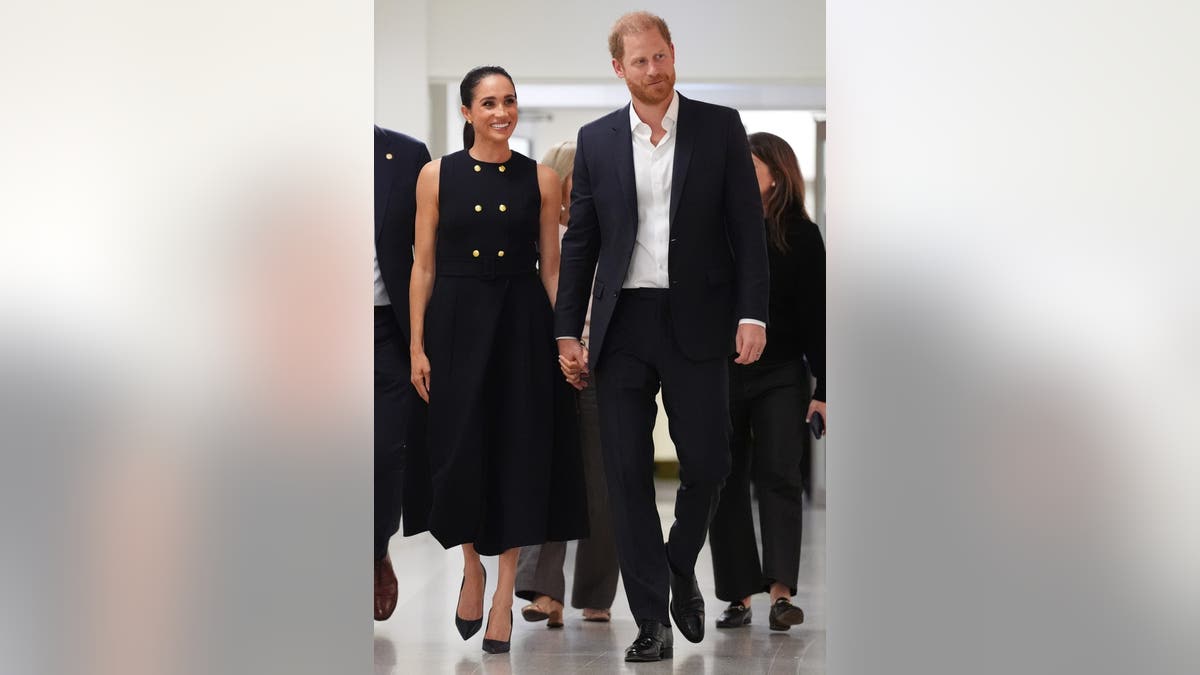Meghan Duchess of Sussex and Prince Harry Duke of Sussex walking holding hands at hospital