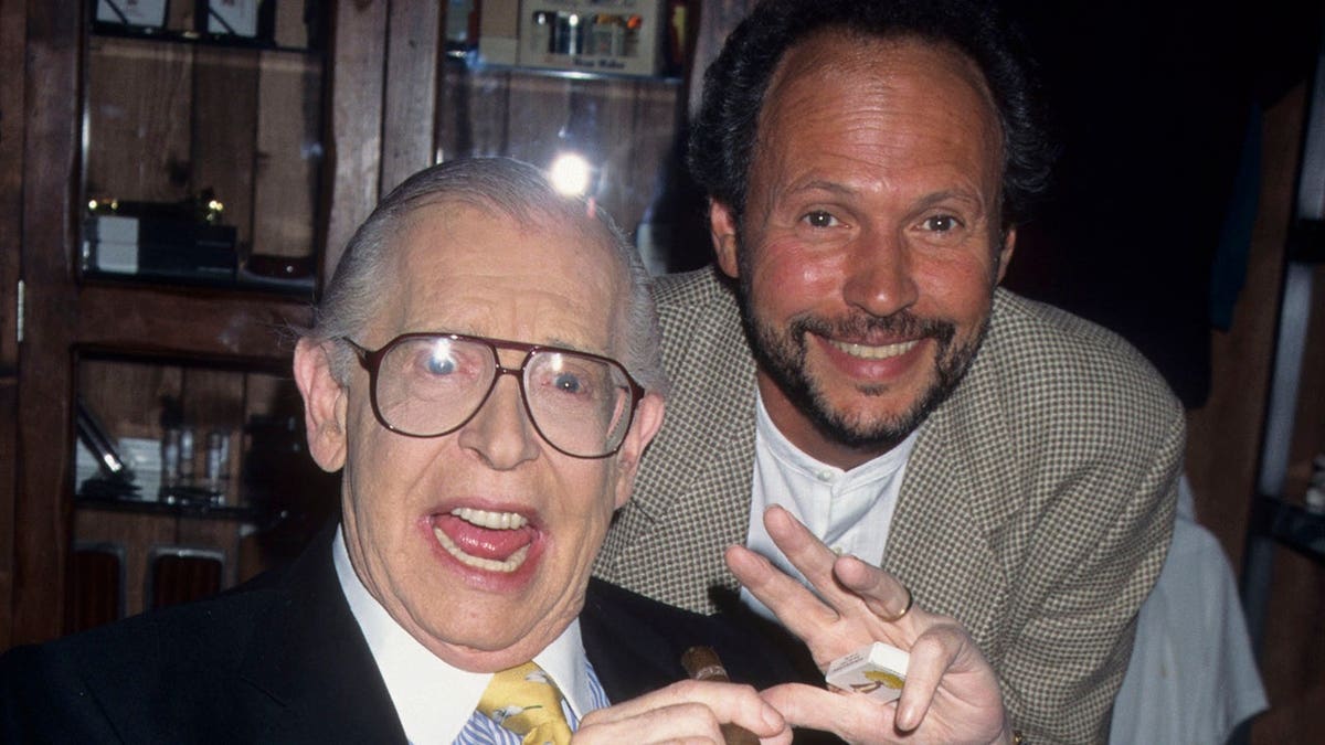 O comediante Milton Berle e o ator Billy Crystal sorrindo juntos