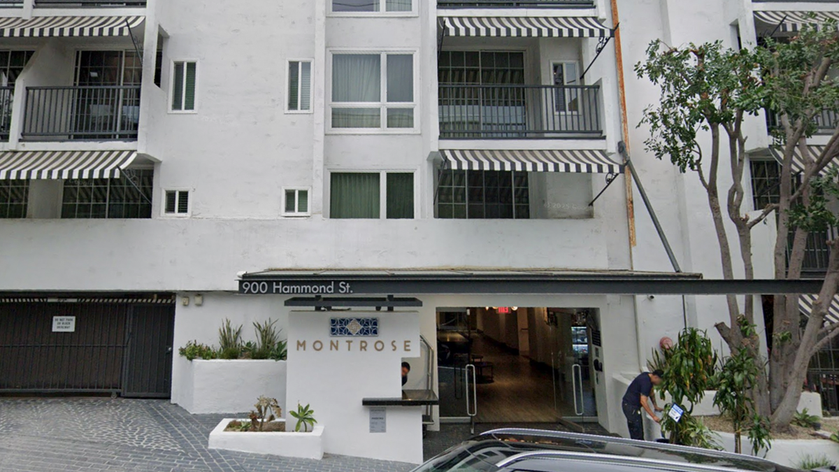 The Montrose hotel is on a slightly inclined street, with balcony's and striped awnings visible.