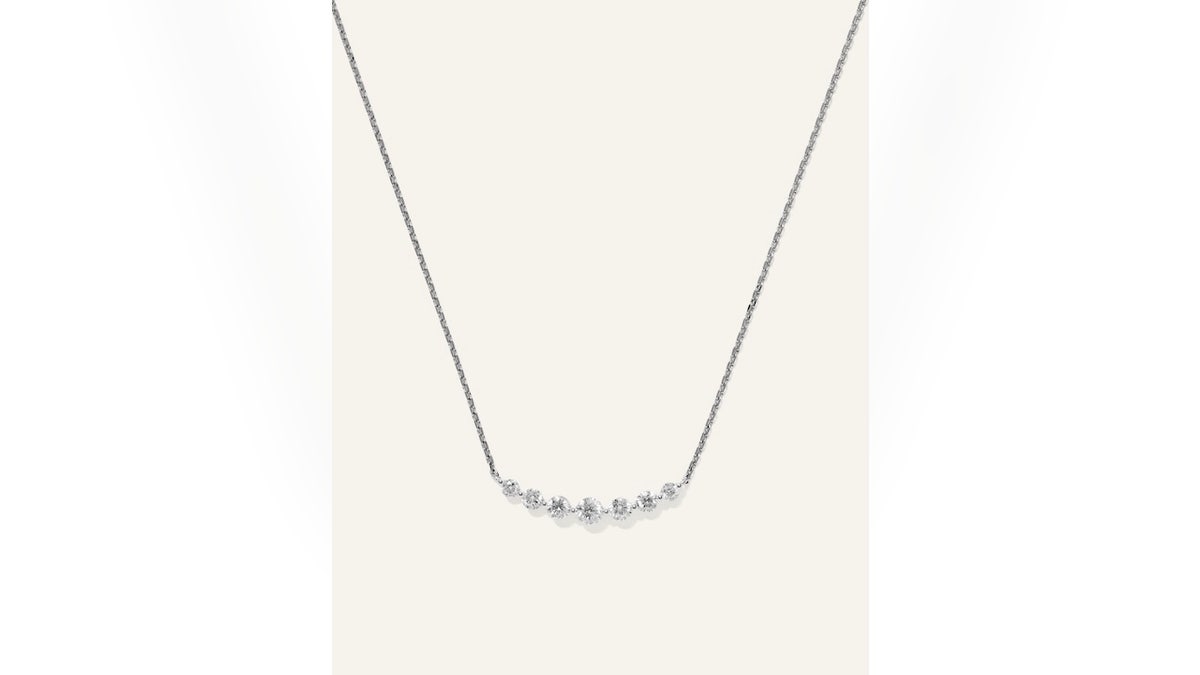 Este colar em barra de ouro 14K apresenta sete diamantes.