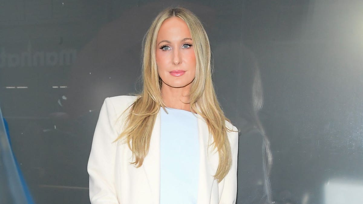 Nikki Glaser poses in blue dress