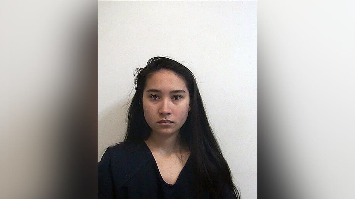 Booking photo of Angelina Han Hicks, an 18-year-old woman with long dark hair.