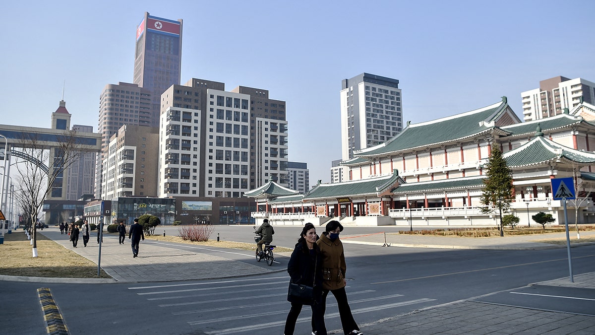 People walk down a street.