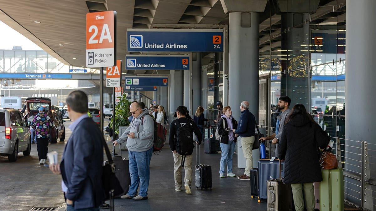 Travelers waiting at a ride share pick up point at O'Hare International Airport in Chicago