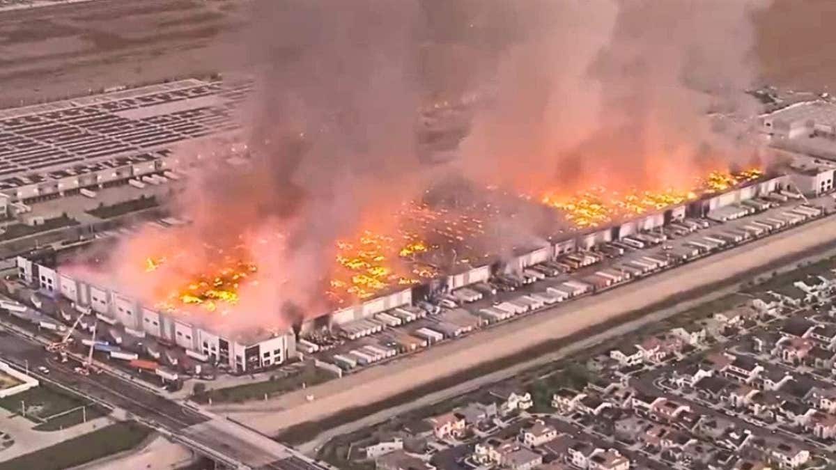Aerial presumption    of a ample  warehouse occurrence  with flames and heavy   fume  rising implicit    an concern   gathering  successful  Ontario, California.